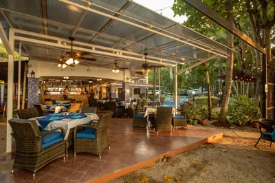 an outdoor dining area with a table and chairs at Hotel El Velero in Playa Hermosa