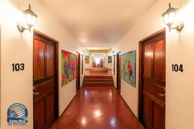 a hallway with wooden doors and a hallway with stairs at Hotel El Velero in Playa Hermosa
