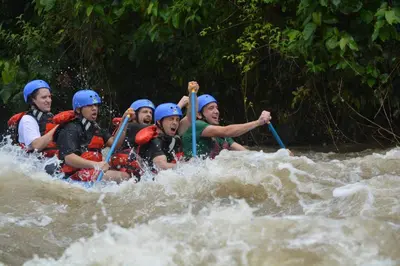 a group of people on a raft in a river at La Fortuna Lodge by Treebu Hotels in Fortuna