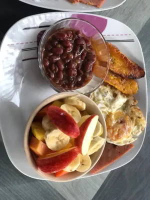 a plate of breakfast food with beans and toast at Apartamentos Equipados DMR #3 in Uvita