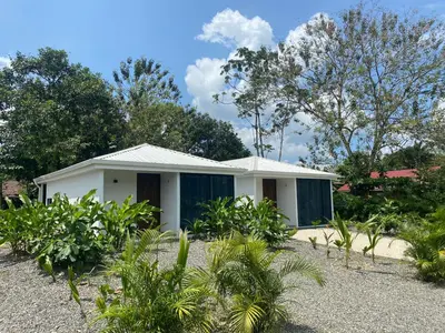 a small white house with a lot of plants at Villa Sueños del Arenal in Fortuna