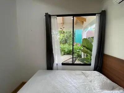 a bedroom with a window looking out at a garden at Villa Sueños del Arenal in Fortuna