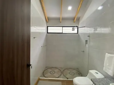 a white bathroom with a toilet and a shower at Villa Sueños del Arenal in Fortuna