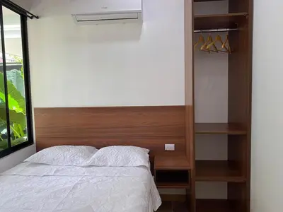 a bedroom with a bed with a wooden headboard at Villa Sueños del Arenal in Fortuna