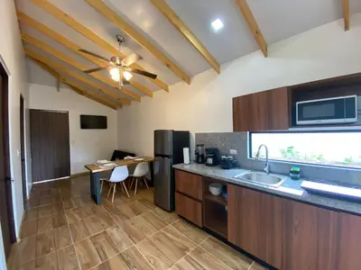 a kitchen with a refrigerator and a table at Villa Sueños del Arenal in Fortuna