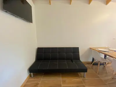 a black couch in a room with a table at Villa Sueños del Arenal in Fortuna