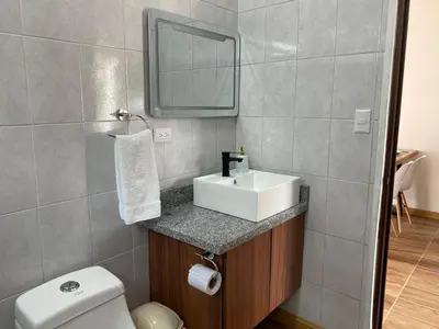 a bathroom with a sink and a toilet and a mirror at Villa Sueños del Arenal in Fortuna
