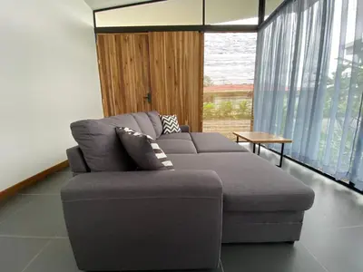 a gray couch in a living room with a table at Villa Tanager in Fortuna