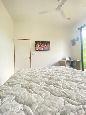 a bedroom with a large bed with a painting of a cat at Villa Tanager in Fortuna