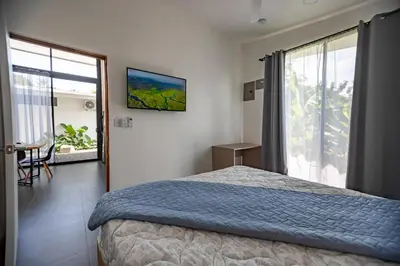 a bedroom with a bed and a large window at Villa Tanager in Fortuna