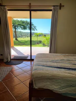a bedroom with a bed and a large window at Hacienda en Los Volcanes in Hacienda Guayabo