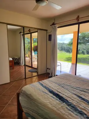 a bedroom with a bed and a sliding glass door at Hacienda en Los Volcanes in Hacienda Guayabo