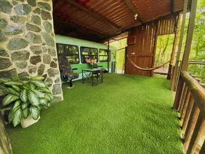 a house with a green floor and a bus at Ficus Wonders Bus in Monteverde Costa Rica
