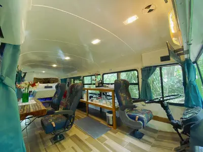 a bus with chairs and a table and a bed at Ficus Wonders Bus in Monteverde Costa Rica