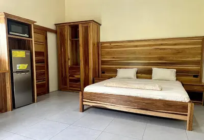 a bedroom with a bed and a refrigerator at Tico casita - Lero Stays in Fortuna