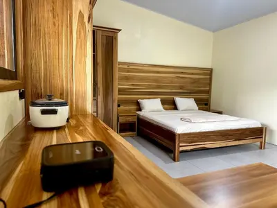 a small bedroom with a bed and a black suitcase at Tico casita - Lero Stays in Fortuna