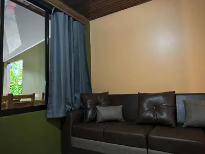 a couch in a living room with a window at Tico casita - Lero Stays in Fortuna