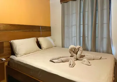 a bedroom with a bed with two towels on it at Tico casita - Lero Stays in Fortuna