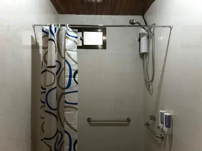 a bathroom with a shower with blue and white graffiti at Tico casita - Lero Stays in Fortuna