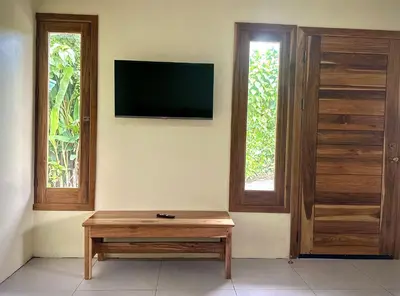 a living room with a tv and a wooden coffee table at Tico casita - Lero Stays in Fortuna