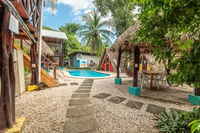 a resort with a swimming pool and a house at Playa Grande Surf Camp in Playa Grande