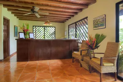 a lobby with a reception desk and chairs at Manatus Hotel in Tortuguero