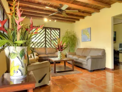 a living room with couches and a ceiling fan at Manatus Hotel in Tortuguero