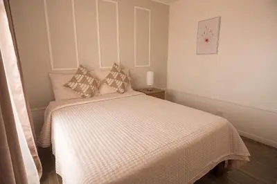 a bedroom with a bed with a white comforter and pillows at Victoria´s House in Grecia