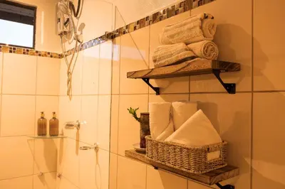 a bathroom with a shower with towels and a basket at Victoria´s House in Grecia