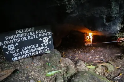 a person is cooking over a fire in a cave at Recreo Verde Hot Springs & Spa in Marsella