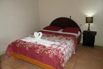a bedroom with a bed with two swans on it at Hotel Vista al Tortuguero in Cariari