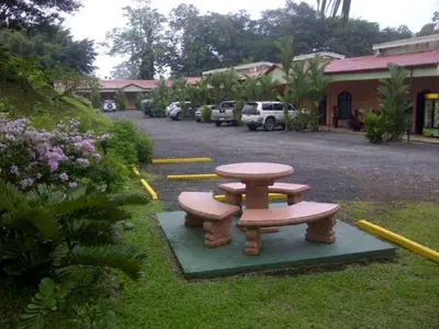 a picnic table and two benches in a yard at Hotel Vista al Tortuguero in Cariari