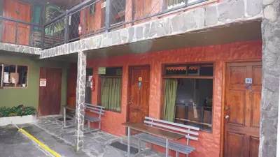 a building with two benches on the side of it at Manakin Lodge, Monteverde in Monteverde Costa Rica