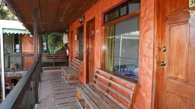 a porch of a wooden house with a window and a door at Manakin Lodge, Monteverde in Monteverde Costa Rica