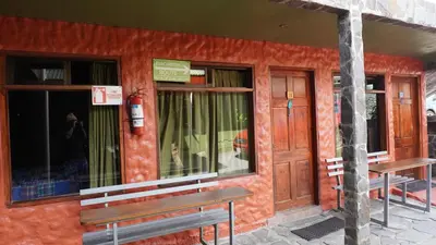 a red building with two benches outside of it at Manakin Lodge, Monteverde in Monteverde Costa Rica