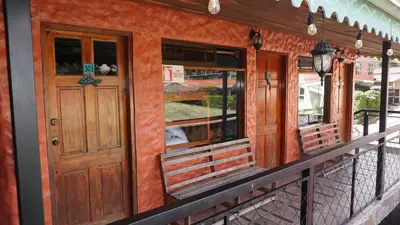 a front porch of a house with a wooden door at Manakin Lodge, Monteverde in Monteverde Costa Rica