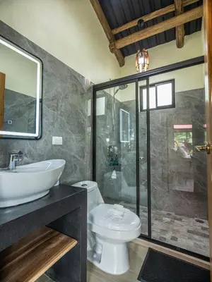 a bathroom with a shower and a toilet and a sink at Cabañas Caeli, El Toucan, Peaceful Rainforest Retreat with Stunning Views in Fortuna