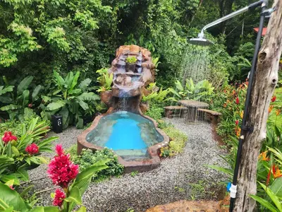 a fountain in the middle of a garden at Cabañas Caeli, El Toucan, Peaceful Rainforest Retreat with Stunning Views in Fortuna