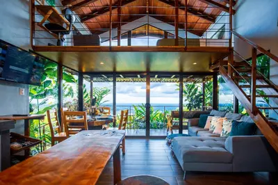 a living room with a couch and a table at Cabañas Caeli, La Perezosa, La Fortuna Rainforest Glass Cabin w Amazing Views in Fortuna