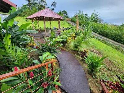a garden with a walkway and a gazebo at Cabañas Caeli, La Perezosa, La Fortuna Rainforest Glass Cabin w Amazing Views in Fortuna