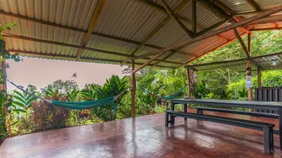 a hammock on a porch with a hammock at Cabañas Caeli, La Perezosa, La Fortuna Rainforest Glass Cabin w Amazing Views in Fortuna