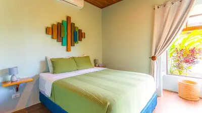 a bedroom with a bed and a window at Cabañas Caeli, La Perezosa, La Fortuna Rainforest Glass Cabin w Amazing Views in Fortuna
