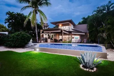 a house with a swimming pool in front of a house at 8min Walk to Beach, Pool Villa, 24-7 Concierge in Tamarindo