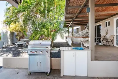 an outdoor kitchen with a stove and a patio at 8min Walk to Beach, Pool Villa, 24-7 Concierge in Tamarindo