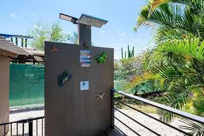 a metal door with stickers on it next to a fence at 8min Walk to Beach, Pool Villa, 24-7 Concierge in Tamarindo