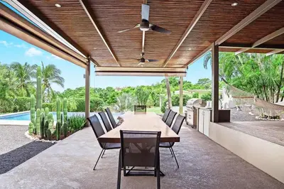 an outdoor dining room with a table and chairs at 8min Walk to Beach, Pool Villa, 24-7 Concierge in Tamarindo