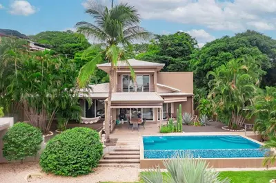 a house with a swimming pool in front of it at 8min Walk to Beach, Pool Villa, 24-7 Concierge in Tamarindo