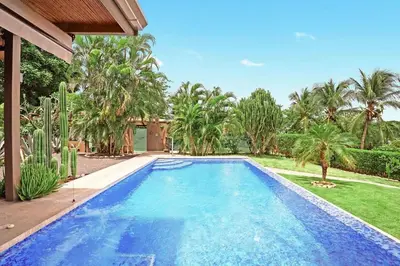 a swimming pool in a yard with palm trees at 8min Walk to Beach, Pool Villa, 24-7 Concierge in Tamarindo