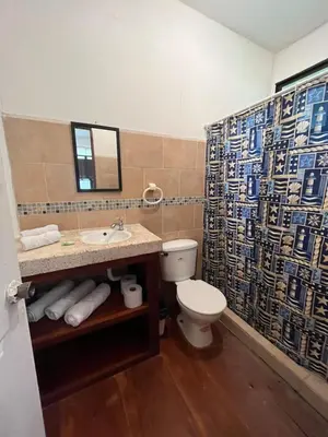a bathroom with a toilet and a sink and a mirror at La Perla de Cobano in Puntarenas