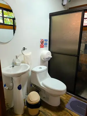 a bathroom with a toilet and a sink at Arenal Sweet Cabins in Fortuna
